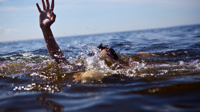 Person drowning in water with hand reached out