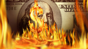 Burning dollar sign and fire flames over one hundred dollar bill